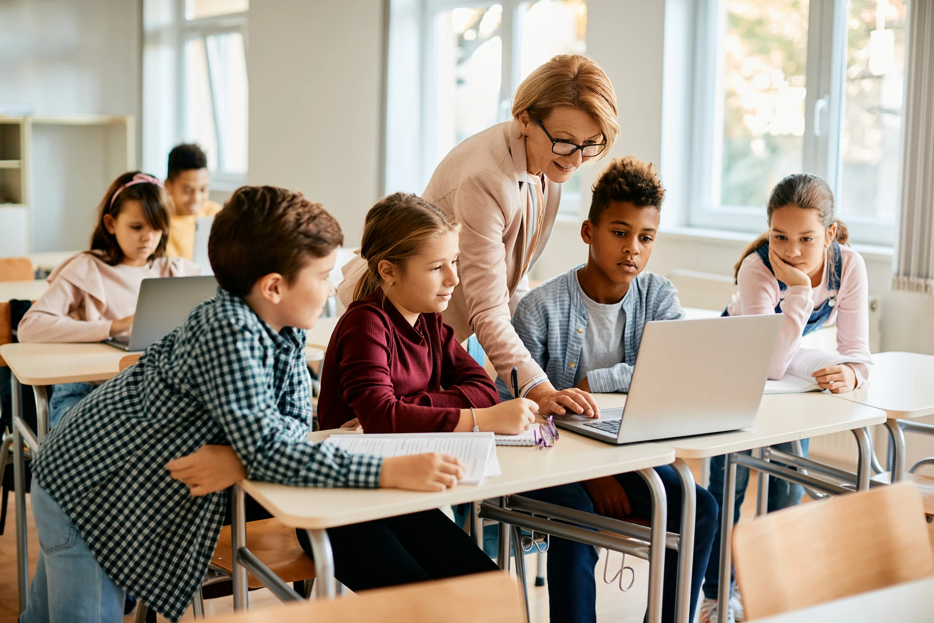 teacher helping her students in class